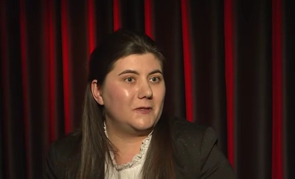 femeie satena cu parul prins pe fundalul unei copertine grena