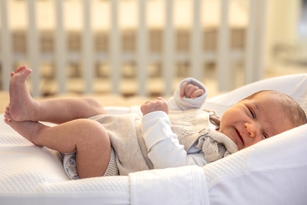 copil imbracat in body alb plange in patut