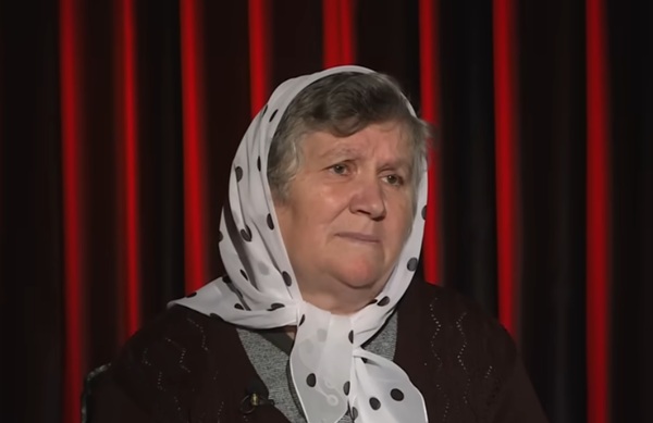 femeie cu batic alb pe cap cu model in spate o copertina grena din catifea