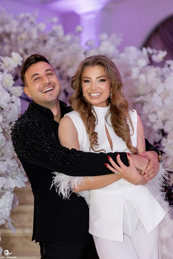 valentin sanfira in costum negru o tine in brate pe sotia lui in rochie alba