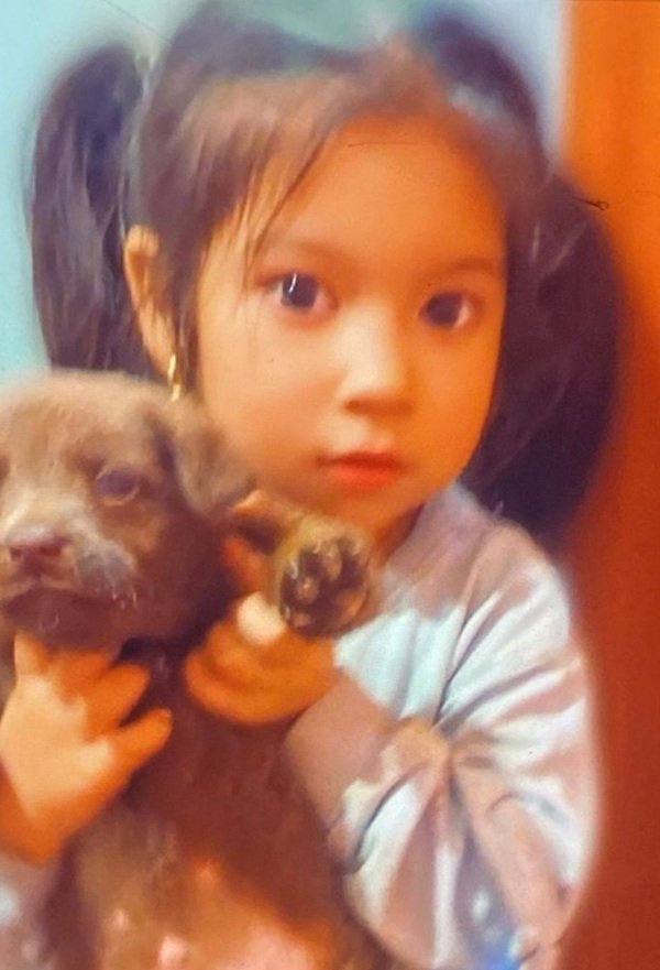 fetita cu codite tine un catelus in brate