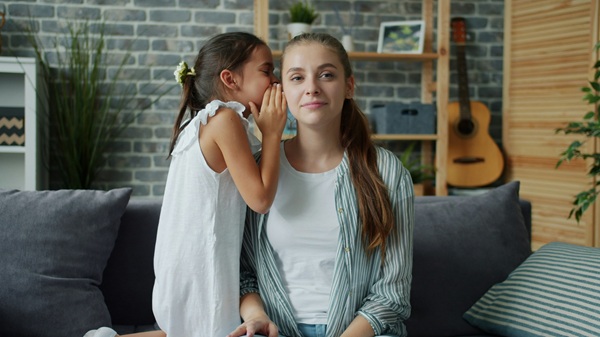 fetita imbracata in alb ii sopteste mamei un secret la ureche