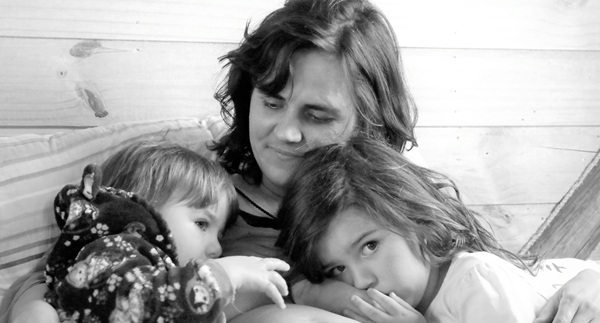 fotografie alb negru cu o femeie care tine doi copii in bratele ei