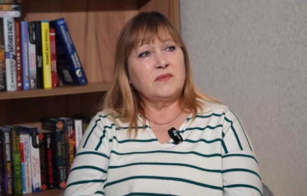 femeie cu parul blond tunsa scurt cu bluza in dungi