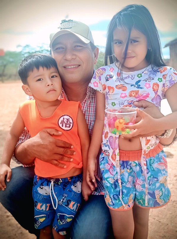 un tata isi tine copiii in brate un baiat si o fetita