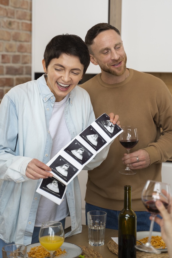 femeie tine ecografie bebelus in mana alaturi de barbat la amsa