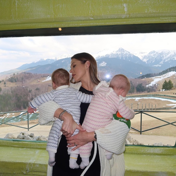 roxana nemes isi tine bebelusii in brate in spate peisaj alpin