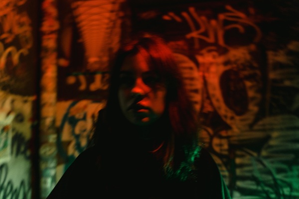 fata cu parul mediu saten imbracata in negru la subsolul unui bloc