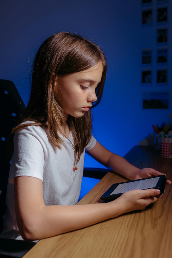 fata in tricou alb se uita pe telefon