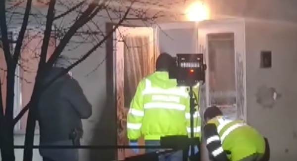 politisti cauta pe prispa unei case