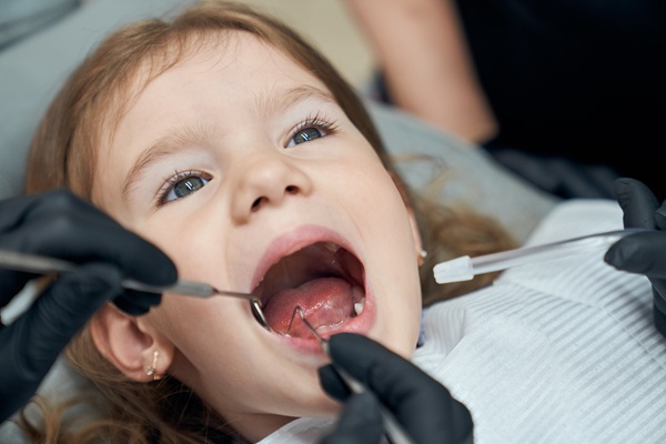 fetita blonda tine gura larg deschisa la dentist