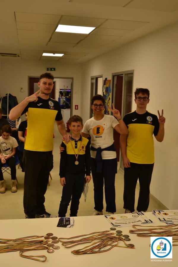 patru copii imbracati in galben unul dintre ei are medalie