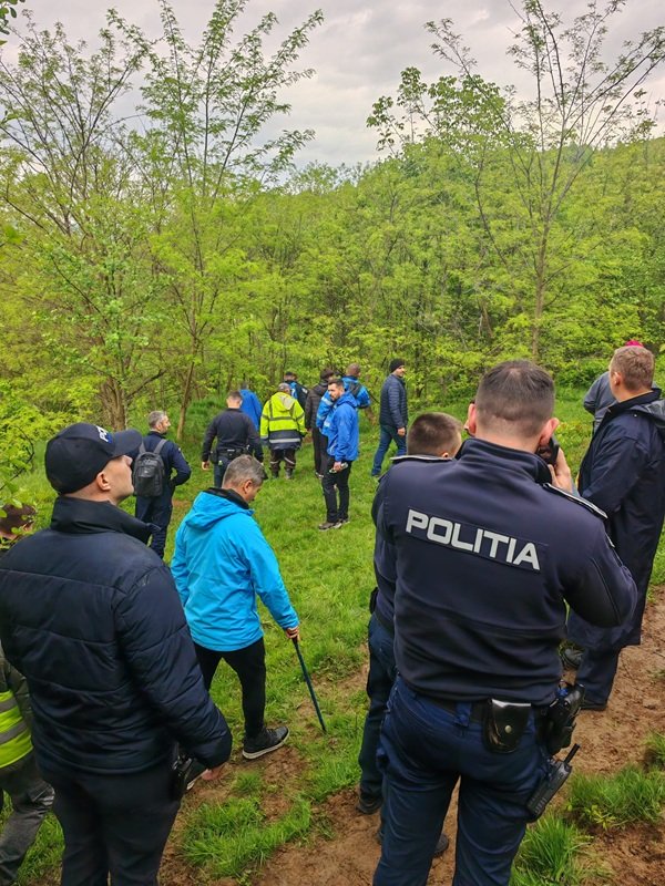 oamenii legii si cetateni cauta un copil prin padure
