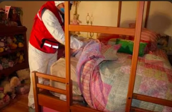 un anchetator cerceteaza patul in care a murit o fetita asfixiata