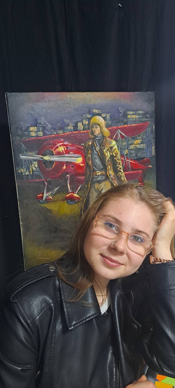 rebecca laptes cu ochelari la ochi si geaca de piele duce mana in par