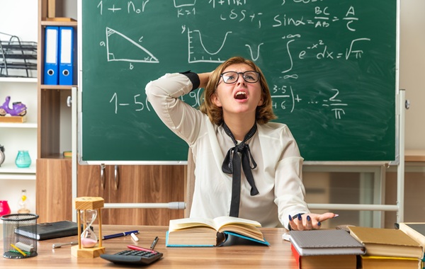 profesoara in camasa alba cu funda neagra la gat suparata la catedra