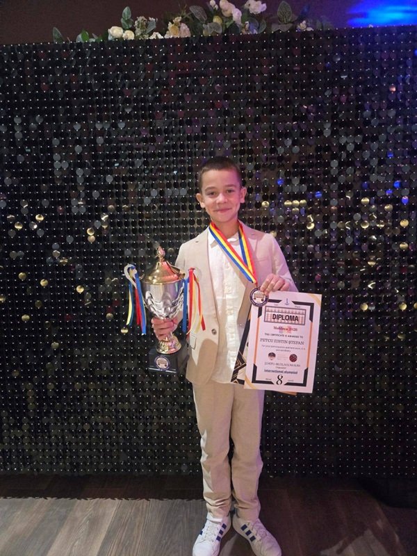 iulian petcu imbracat in alb tine in mana o diploma