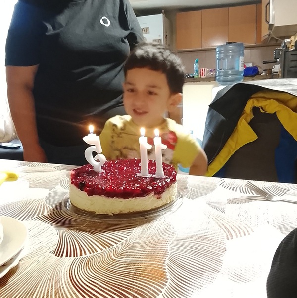 baiat tuns scurt sufla in lumanarile de pe tort