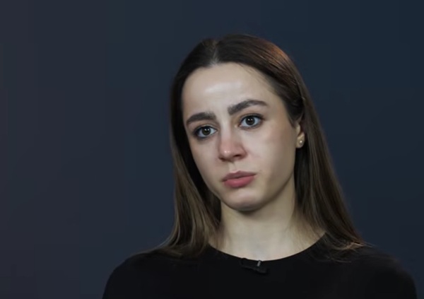 femeie satena cu parul lung imbracata in negru pe fundal albastru