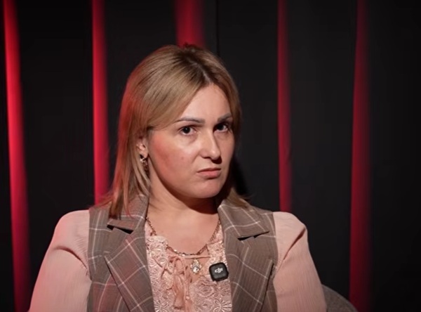 femeie cu parul saten imbracata in roz cu o vesta pe ea