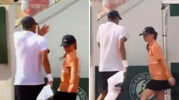 jucator de tenis imbracat in alb trece pe langa o fetita imbracata in portocaliu