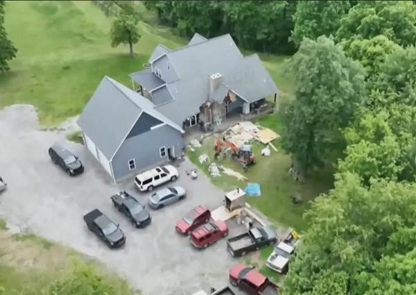 imagine de sus cu o casa daramata de excavator cu masini in curte