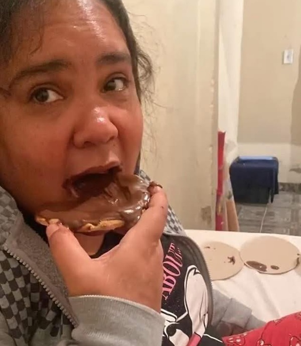 femeie bruneta mananca o felie de paine cu ciocolata pe ea