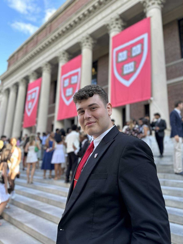 alexandru draghia in costum negru pe scarile universitatii harvard