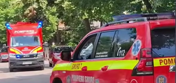 doua ambulante smurd rosii parcate pe o strada cu copaci infrunziti