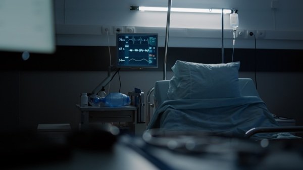 un pat de spital in lumina difuza