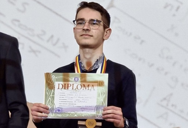 emanuel mazare imbracat in negru tine o diploma in mana
