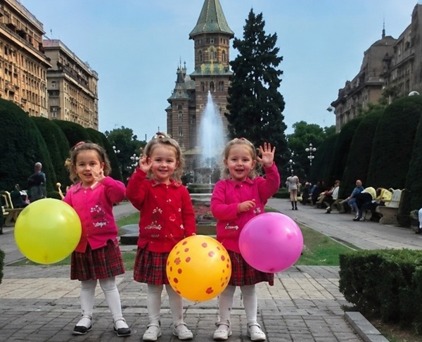 trei fete triplete imbracate la fel tin baloane colorate in mana