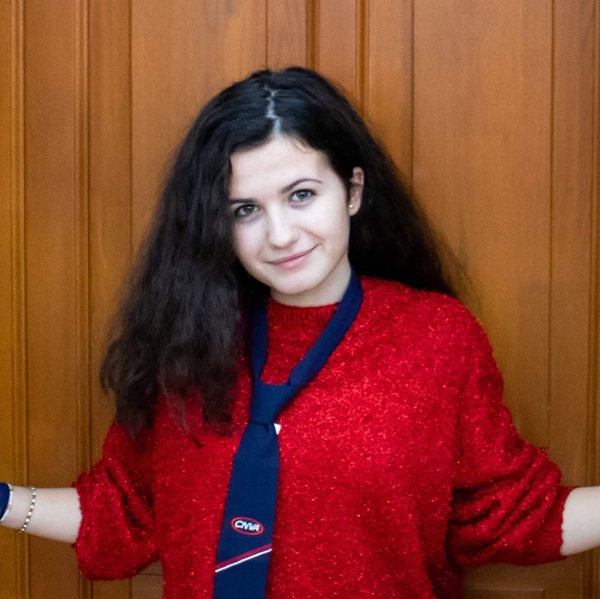 daria harabor imbracata in rosu cu o cravata albastra la gat