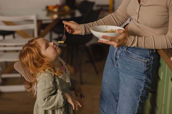 mama ii da unui copil cu lingura mancare