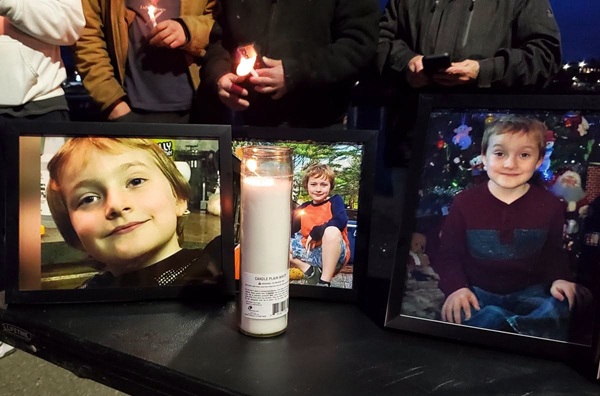 un altar cu o lumanare alba groasa si mai multe poze ale unui baiat