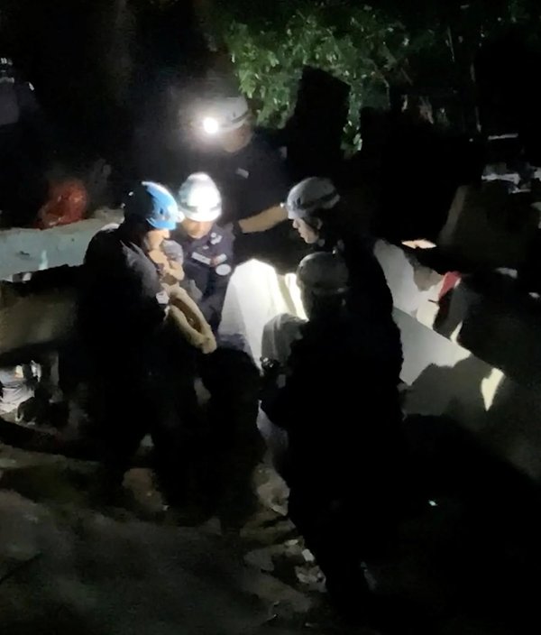 oameni care sunt stransi langa daramaturi