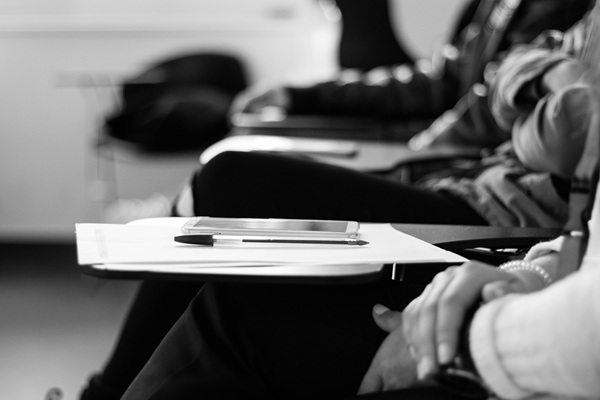 poza alb negru cu elevi care sustin un examen