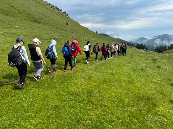 grup de turisti se intoarce pe traseu montan