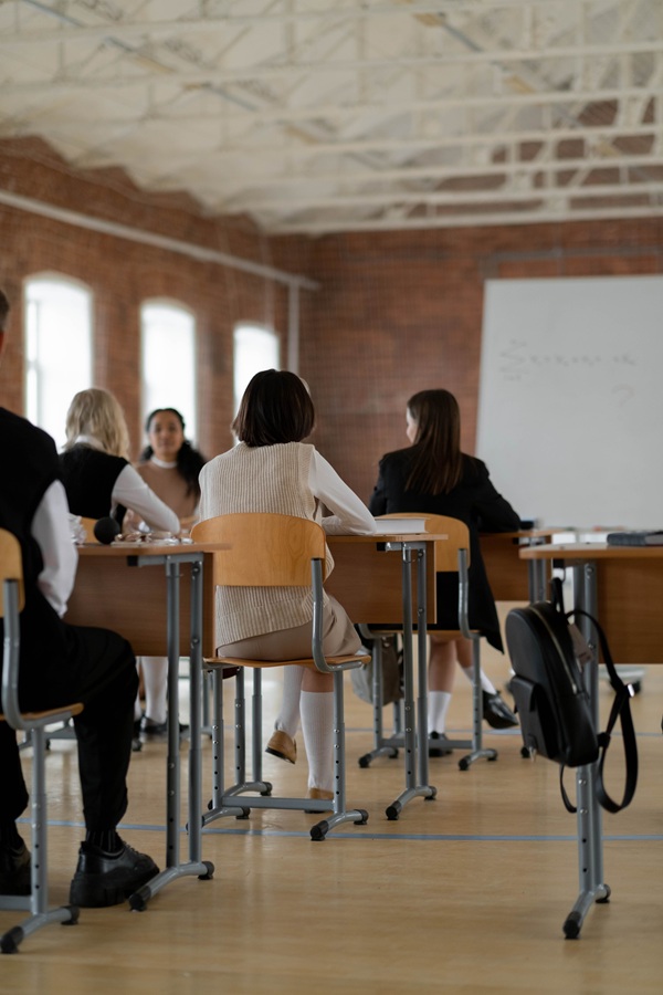 elevi stau in banci si scriu intr-o sala de clasa