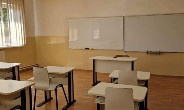 sala de clasa goala cu banci albe si doua table albe