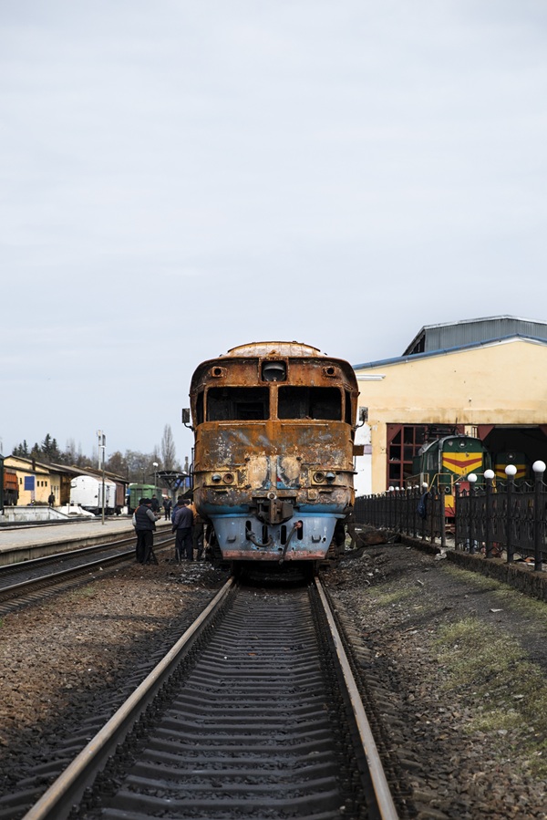 tren intr-o gara cu mai multe persoane stranse pe linia de cale ferata