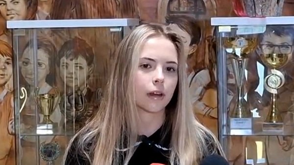 fata cu parul lung desprins blond sustine un interviu printre trofee