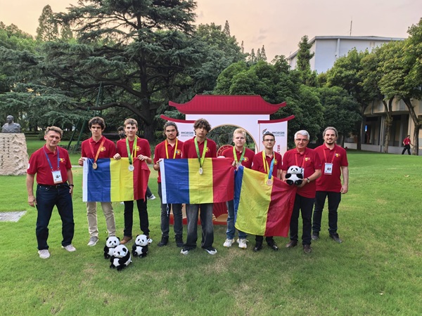 6 baieti impreuna cu 3 profesori tin steagul romaniei in mana toti au medalii la gat si sunt in china in spate o casuta in stil chinezesc
