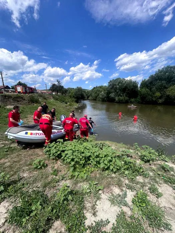 scafandri imbracati in rosu pe malul raului mures cu barci de salvare