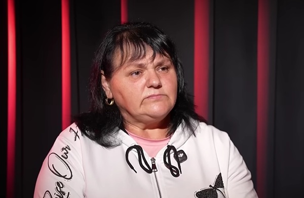 femeie bruneta cu par mediu imbracata in alb cu microfon la gat