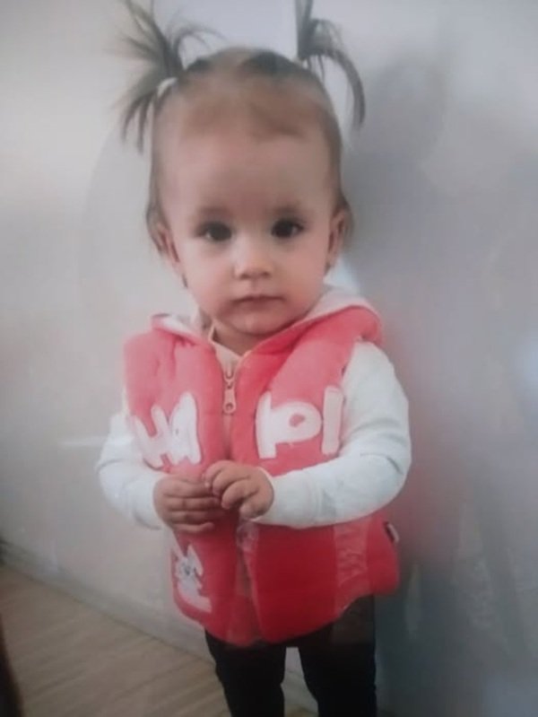 fetita cu codite si o vesta rosie pe ea
