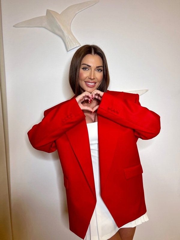 ilinca vandici imbracata in sacou rosu oversized face semnul inimii cu degetele