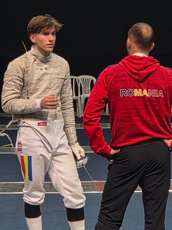 matei radu imbracat in costum de scrima impreuna cu antrenorul