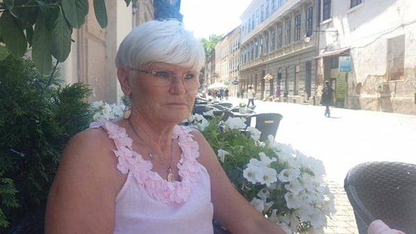 monica tatoiu in maieu roz sta la o masa si priveste in zare in natura