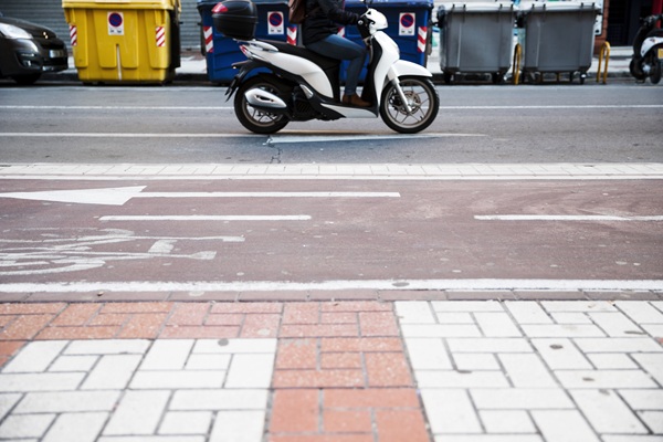 femeie pe un moped in oras se plimba